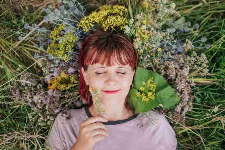 woman blissfully relaxing in a field of flowers