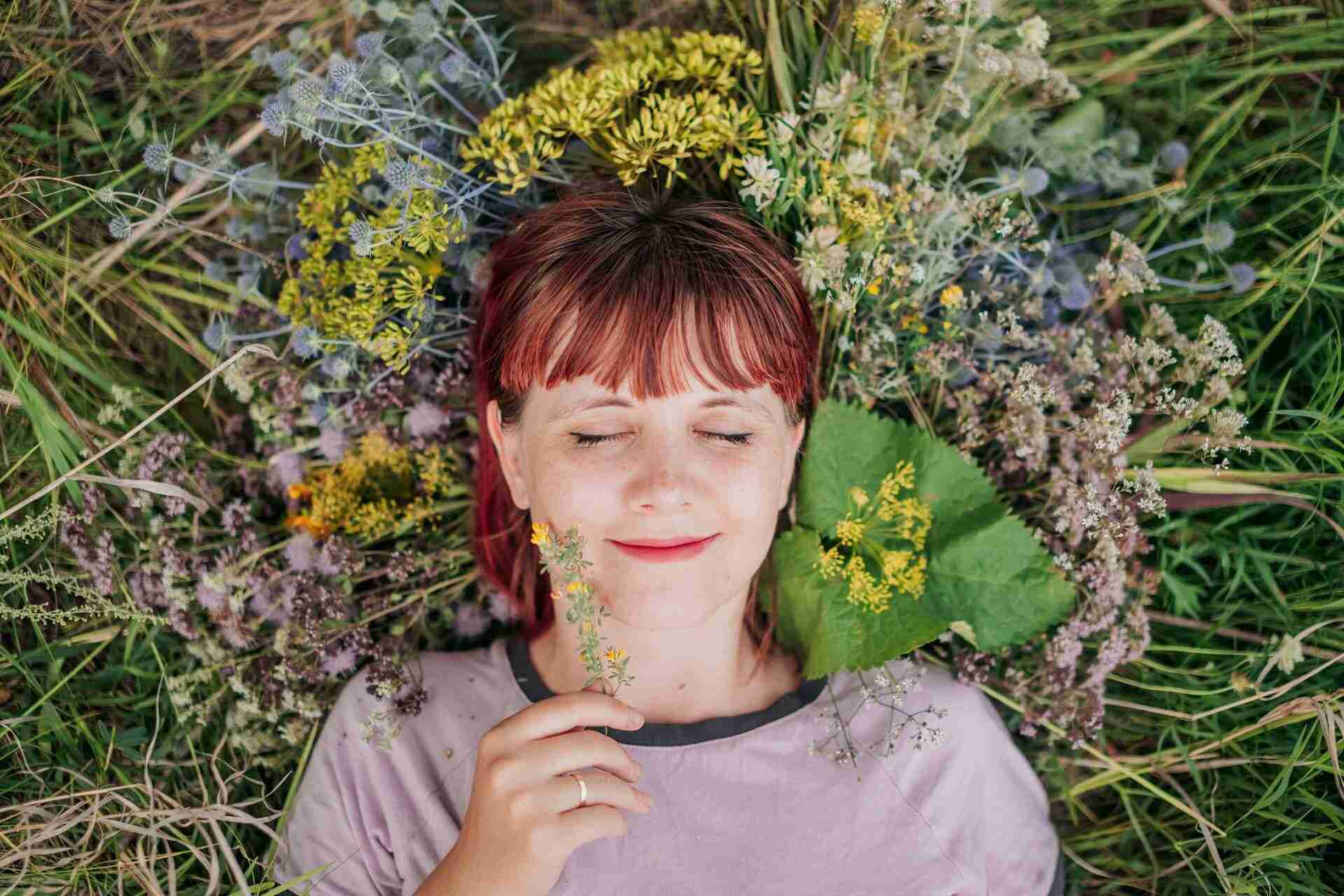 woman blissfully relaxing in a field of flowers